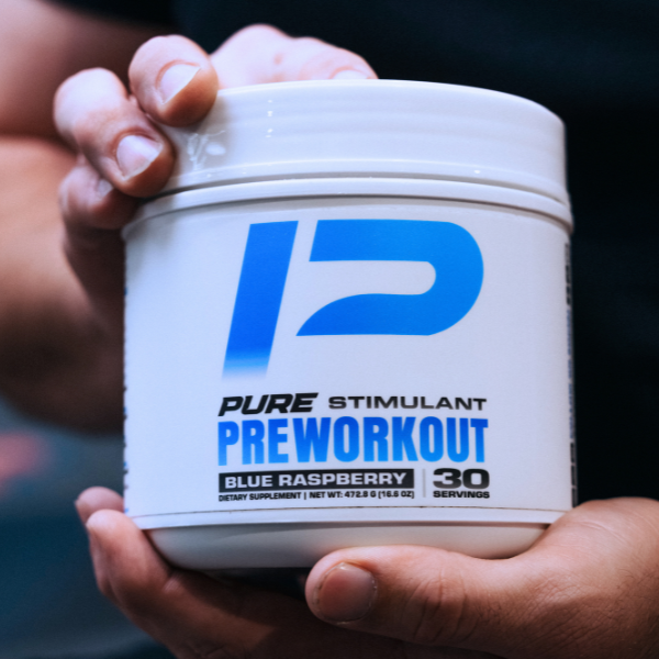 Container of Pure Preworkout supplement held by a person